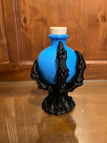 Blue decorative potion bottle held by a black skeletal claw